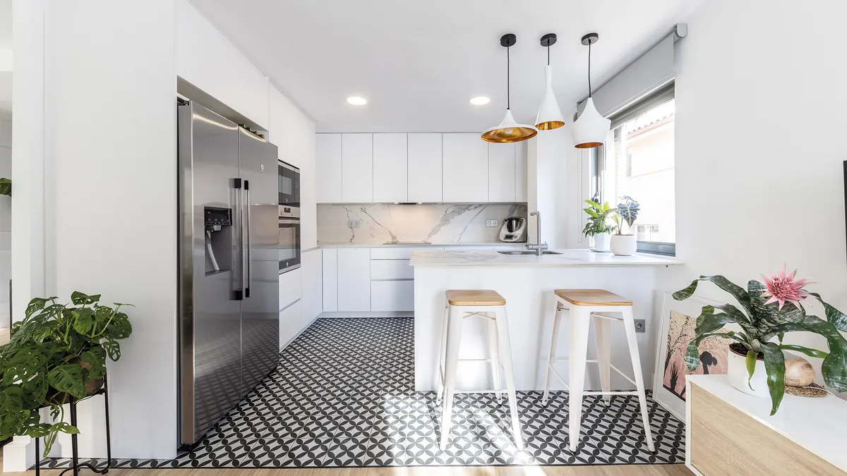 Cocina blanca con suelo hidráulico y taburetes de madera